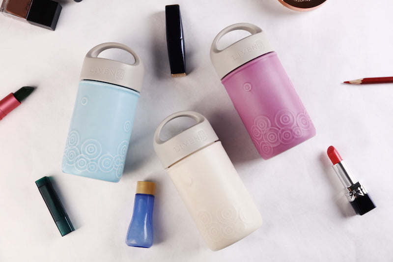 Colorful cylindrical containers with handles on a white background
