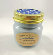 Caribbean Teakwood Soy Candle in glass jar with gold lid and blue anchor-printed top, hand-poured warm woodsy scent by Mam Jam’s