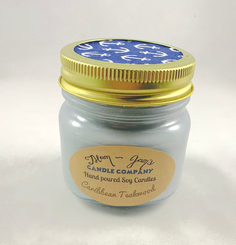 Caribbean Teakwood Soy Candle in glass jar with gold lid and blue anchor-printed top, hand-poured warm woodsy scent by Mam Jam’s