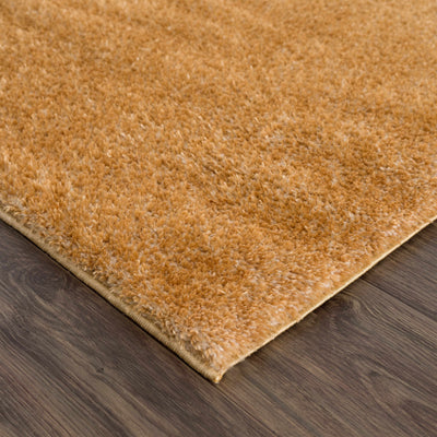 Close-up of Heavenly Solid Mustard Plush Rug with thick dark gold plush pile on wooden floor