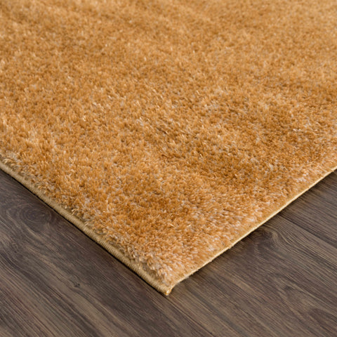 Close-up of Heavenly Solid Mustard Plush Rug with thick dark gold plush pile on wooden floor