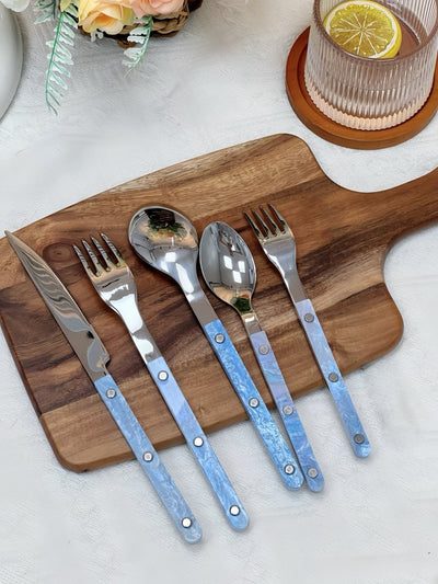 Set of 10 modern nebula cutlery with turquoise rivet handles displayed on wooden board